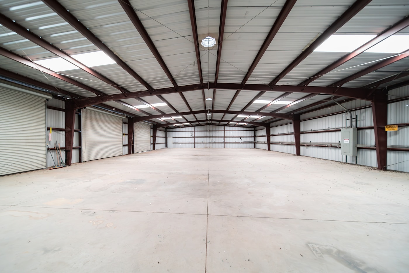 Cover image for How to Design a Live-Work Barndominium showing Documentary film photo, dusk exterior of a live-work barndominium with clearly separated workshop bay and warm residential entry, one work truck parked near the shop side,.